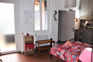 a bedroom with a bed and a kitchen with a window at Maison Toulousaine avec jardin in Toulouse