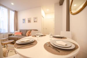 een keuken en een woonkamer met een tafel en een bank bij Cosy home in Paris Center - With AC in Parijs