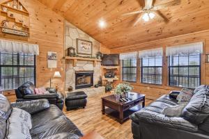 sala de estar con muebles de cuero y chimenea en Inspiration Point Cabin, en Sevierville