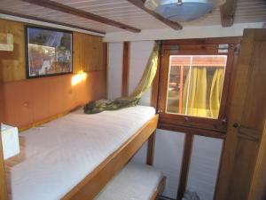 Cette petite chambre comprend 2 lits superposés et une fenêtre. dans l'établissement Boat & breakfast, à Umag