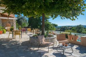 a patio with chairs and tables under a tree at Bastide les 3 Portes in Saint-Paul-de-Vence