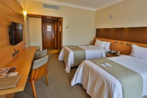 Un pat sau paturi într-o cameră la Bourbon Santos Convention Hotel