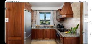 Una cocina con armarios de madera y un fregadero y una ventana. en Villa Calma, en Yaiza 3 fotos más