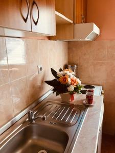 a kitchen sink with a vase of flowers on it at Apartments Vukomanović in Zlatibor