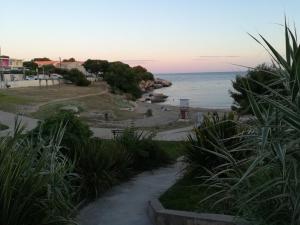 un sentiero che conduce a una spiaggia con l'oceano di Bel appartement avec terrasse - Plage de Carro à pied a Martigues