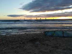 una tenda sulla spiaggia con persone in acqua di Bel appartement avec terrasse - Plage de Carro à pied a Martigues