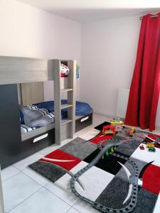 una camera con letti a castello e un trenino giocattolo su un tappeto di Bel appartement avec terrasse - Plage de Carro à pied a Martigues