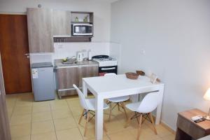 una pequeña cocina con mesa blanca y sillas en AP138 8b Departamento micro Centro Paraná en Paraná