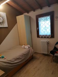 una piccola camera con letto e finestra di La Casa delle Rondini a Montelupo Fiorentino