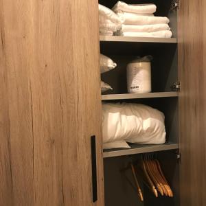 a closet with a wooden door and white towels at Apartman Davidović in Brzeće