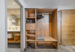 szafa z drewnianymi szafkami i umywalką w obiekcie Apartments & Garni Alpenrose w mieście Obertauern