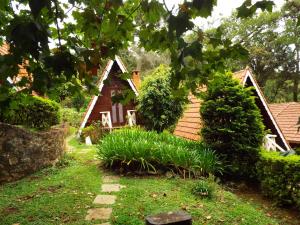 a small house in the middle of a garden at Pousada Perola da Mantiqueira in Monte Verde
