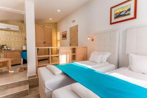 een slaapkamer met 2 bedden en een keuken bij Hotel-Restaurant Kriva Ćuprija in Mostar +37 foto's