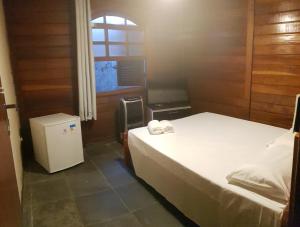 a small room with two beds and a window at Recanto dos Albatrozes in Boicucanga