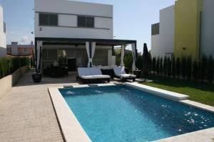 ein Swimmingpool vor einem Haus in der Unterkunft Villa Gala in Cala'n Bosch