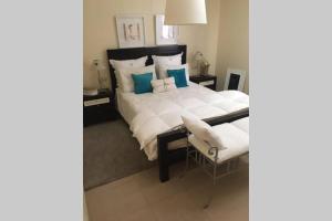 ein Schlafzimmer mit einem großen weißen Bett mit blauen Kissen in der Unterkunft Villa Gala in Cala'n Bosch