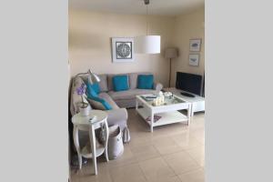 ein Wohnzimmer mit einer Couch und einem Tisch in der Unterkunft Villa Gala in Cala'n Bosch