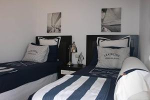2 Betten in einem Schlafzimmer mit blau und weiß in der Unterkunft Villa Gala in Cala'n Bosch