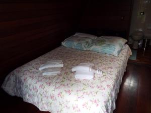 1 cama con 2 toallas y 2 almohadas en Pousada Perola da Mantiqueira en Monte Verde