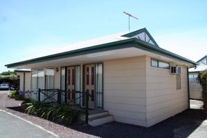 a small house with a porch and stairs to it at West City Motel in Ardeer
