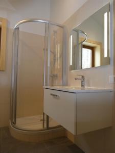 a bathroom with a shower and a sink and a mirror at Chalet Stressless in Presseggen