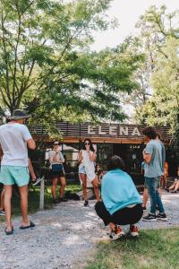 Un groupe de personnes debout autour d'un banc dans un parc dans l'établissement Elena Hostel, à Tandil