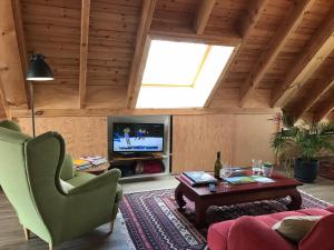 a living room with a tv and a couch and a table at Gastenverblijf Chambre dAmis in Heers