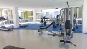 une salle de sport avec plusieurs tapis de course et machines elliptiques dans l'établissement Keys 'N Places Holiday Rentals at Mesaverte Condo, à Cagayán de Oro