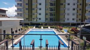 a swimming pool in front of a tall building at Keys 'N Places Holiday Rentals at Mesaverte Condo in Cagayan de Oro