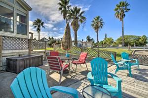 ポートイザベルにあるCozy Waterfront Port Isabel Cottage with Deck!のカラフルな椅子とテーブル付きのパティオ