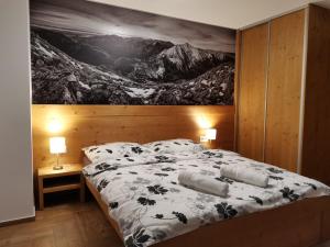 Schlafzimmer mit einem Bett mit Wandgemälde in der Unterkunft Apartmány pod Slavkáčom - Vysoké Tatry in Veľký Slavkov