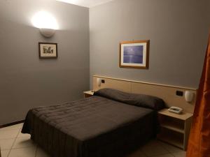 a bedroom with a bed and a picture on the wall at Hotel Ginepro in Qualiano