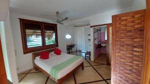 1 dormitorio con 1 cama con 2 almohadas rojas en OceanoMar, en Mazunte