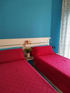 カルダーノ・アル・カンポにあるBnbook Bilo Malpensa 2の青い部屋の赤いカバー付きベッド2台