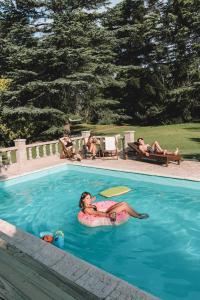 a woman is laying in a swimming pool at Elena Hostel in Tandil