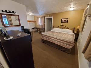 Schlafzimmer mit einem Bett und einem Schreibtisch mit einem Waschbecken in der Unterkunft TKTK in Rapid City