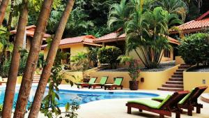a resort pool with chaise lounge chairs and palm trees at Hotel Ritmo Tropical - Pool and Breakfast in Santa Teresa Beach