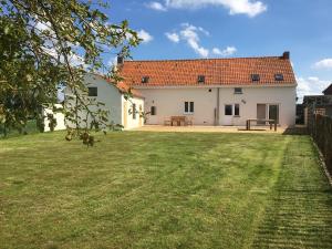 una casa bianca con tetto rosso e cortile di Holiday Home "DEN HUILAERT" Kortemark West Vlaanderen a Kortemark