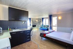 a bedroom with a bed and a kitchen with a sink at Sineva Guest House in Ravda