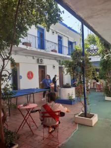 a man sitting on a bench in front of a restaurant at El Viajero Colonia Hostel & Suites in Colonia del Sacramento
