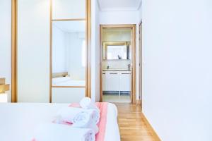 sypialnia z białym łóżkiem i lustrem w obiekcie Urumea 4 - Apartamento con parking w mieście San Sebastián