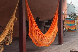 an orange hammock in a room with a table at Pousada Morada da Praia - Balneário Camboriú in Balneário Camboriú