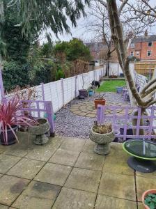 a garden with purple chairs and a white fence at Victorian Townhouse in Banbury