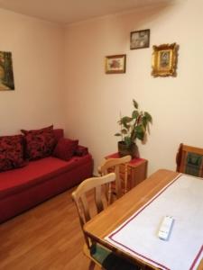 een woonkamer met een rode bank en een tafel bij Apartman Nebojša in Rudnik