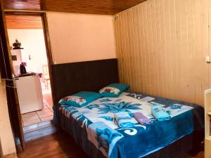a bed with blue sheets and pillows in a room at Casa da Vó Adelina in Urubici