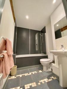 een badkamer met een wastafel, een toilet en een bad bij Stewart Docks Apartment in Gloucester