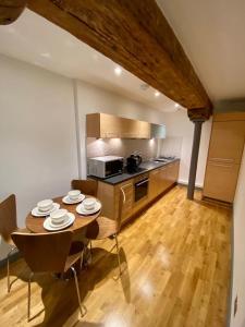 een keuken met een houten tafel en een eetkamer bij Stewart Docks Apartment in Gloucester