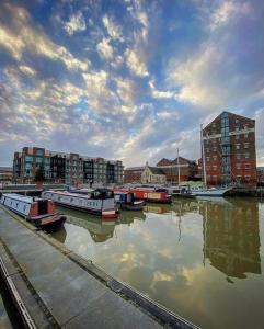 een groep boten aangemeerd in een haven met gebouwen bij Stewart Docks Apartment in Gloucester +6 foto's