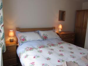 a bedroom with a bed with flowers on it at Deerewood Cottage in Thorpe Market