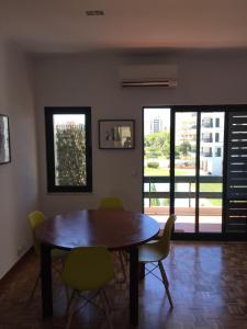 uma sala de jantar com mesa e cadeiras de madeira em Tossan House in Vilamoura Downtown em Quarteira mais 1 fotografia